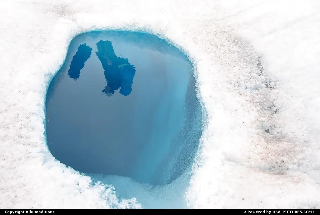 A hiker pass a meltwater pond on the Root Glacier in Wrangell-St.