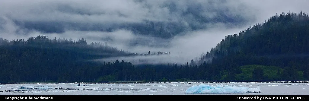 Fingers of fog cling to the hillsides along the shore of the Prince William Sound and c...