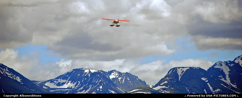 This plane on floats practically dissapear against the glacially carved spires of the C...