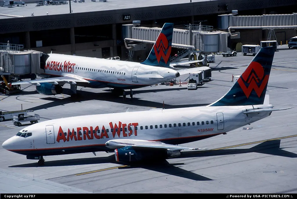 America West at home at Sky Harbour, a Boeing 737-200 taxies to gate past a stablemate...