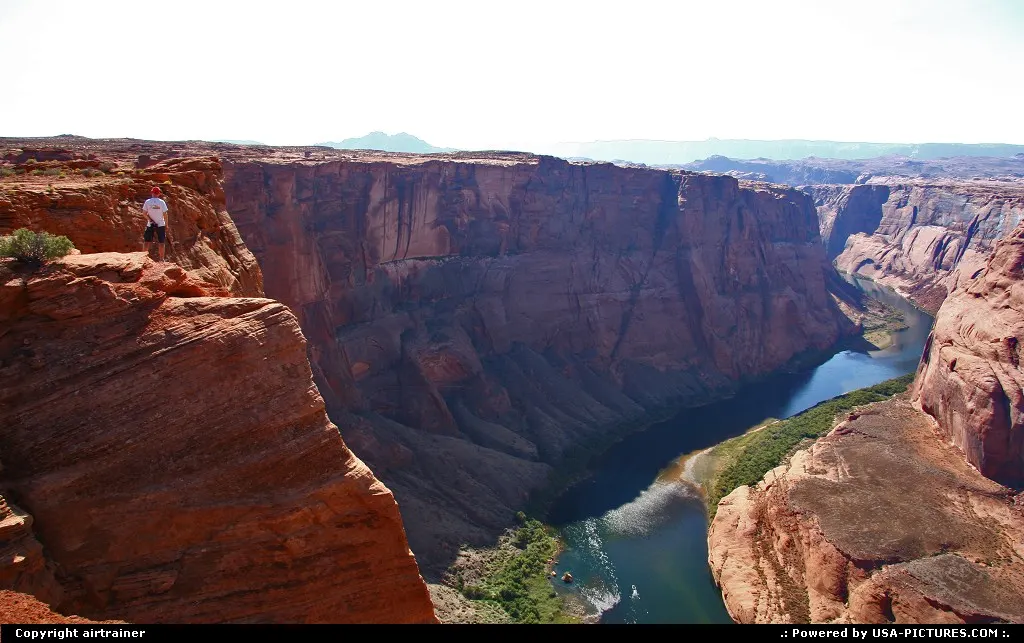a tourist enjoying the view over the Colorado at Horseshoe Bend.