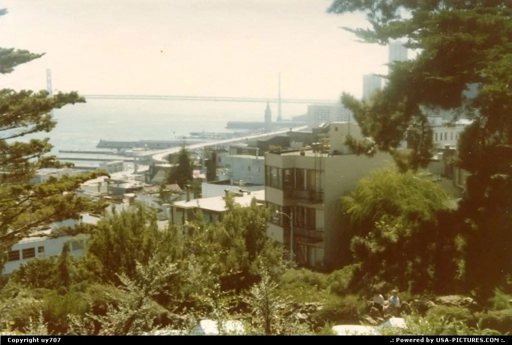 Parts of the Oakland Bay Bridge and piers along the Embarcadero from afar.