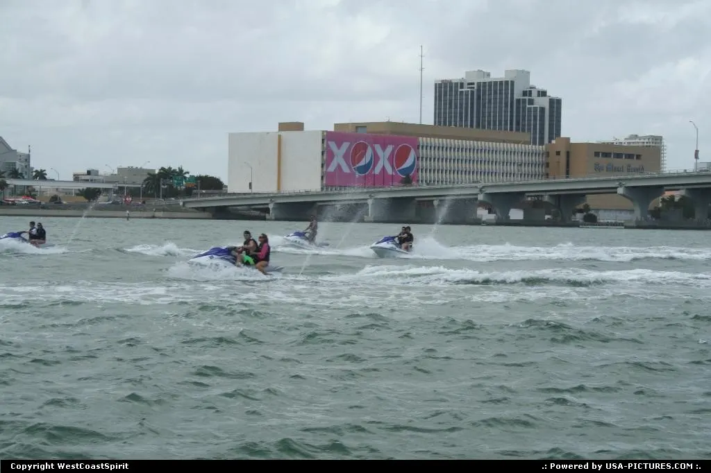 A group having fun with jetski in front of the Miami Herald Tribune building.