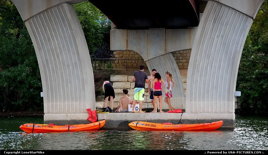 People having a picnic at the base of the Lamar Pedestrian Bridge which spans Lady Bird...