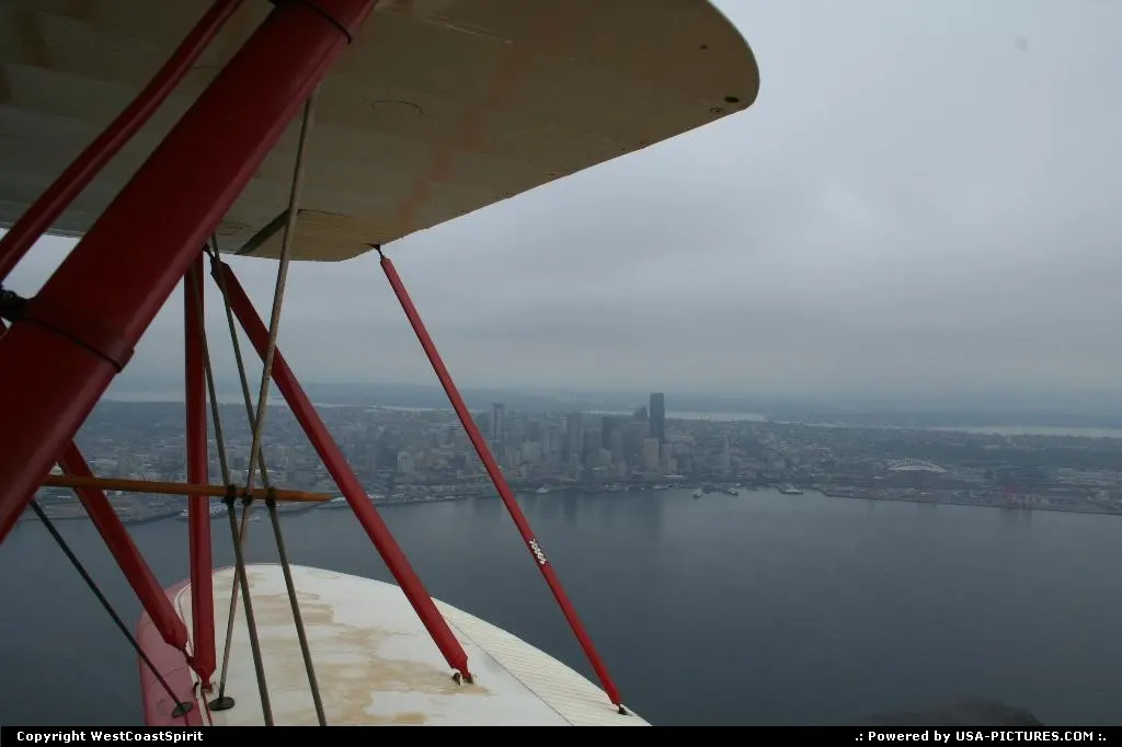 Flying a open roof biplan waco plane above Seattle.