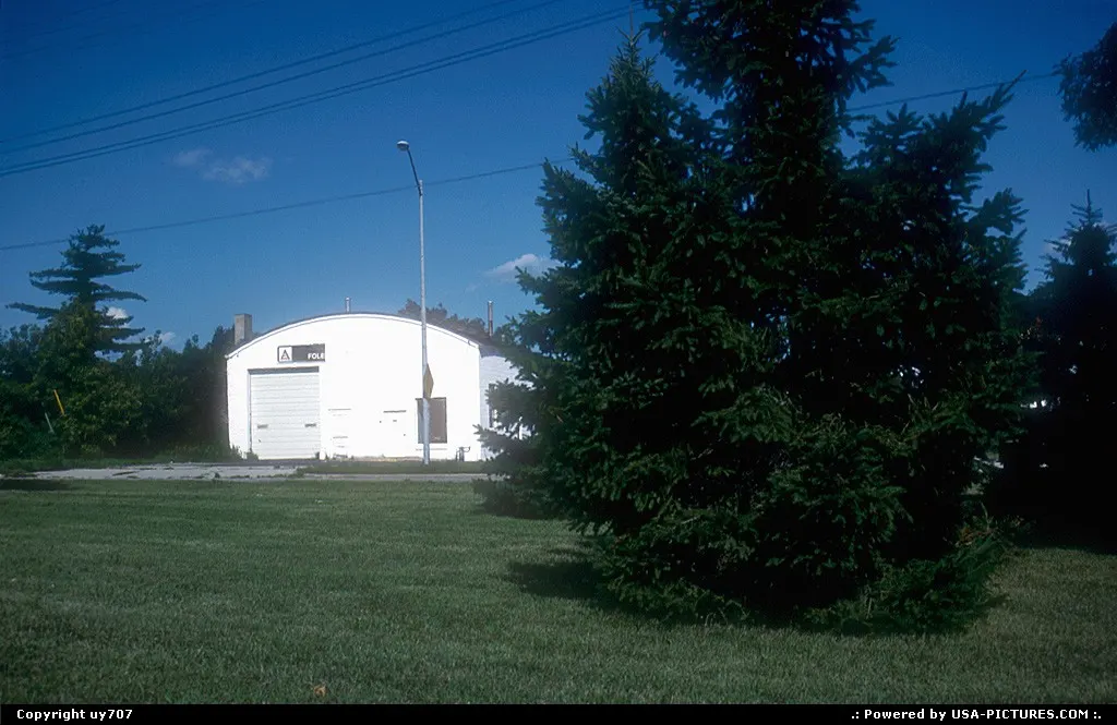 A small warehouse lurking behind some pinetrees